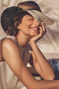 femme-sourire-chapeau-ete-illuminer-visage